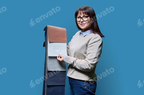 Preview: Woman with samples of fabrics for curtains and upholstery on blue background