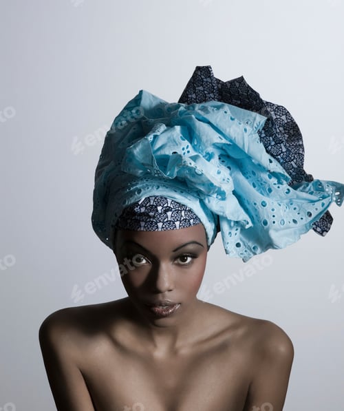Preview: Elegant woman with striking headscarf posing against a neutral background