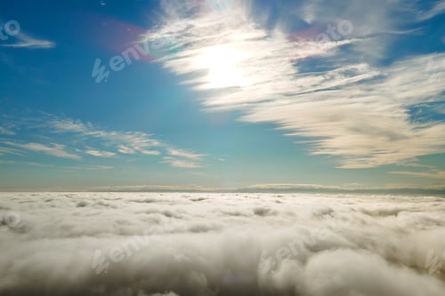 Preview: Aerial view from above of white puffy clouds in bright sunny day.