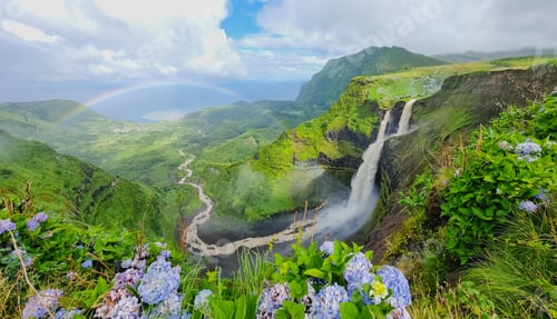 Preview: Rainbow arch with Poco do Bacalhau waterfall and rocky mountains covered with greenery