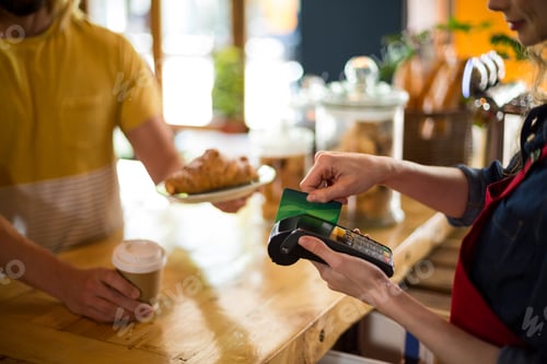 Preview: Customer making payment through credit card at counter in café