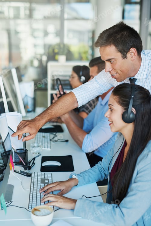 Preview: Shot of a young man assisting his colleague in a call center