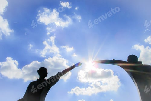 Preview: Skyward view of two silhouetted people reaching out and empowering one another with sun