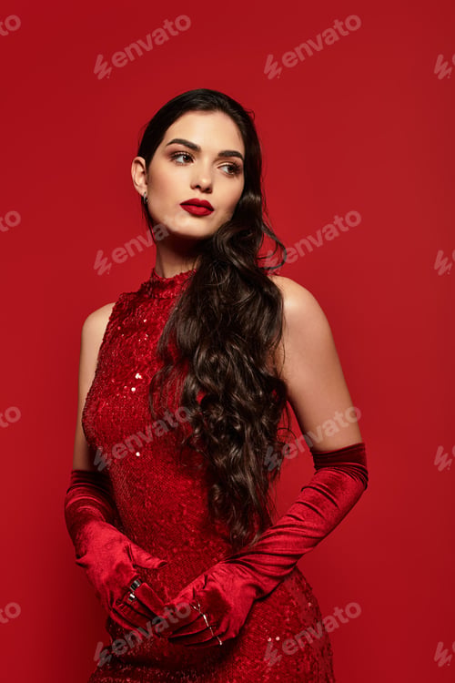 Preview: Striking beauty in red attire showcases elegance and grace in a studio setting