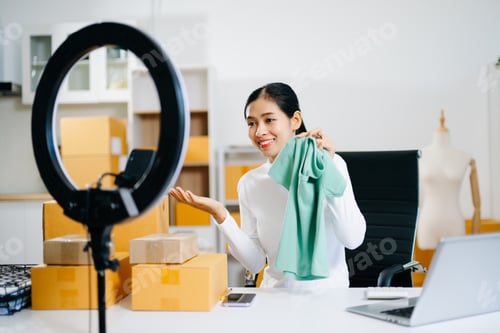 Preview: Fashion blogger concept, Young Asian women selling clothes on video streaming.