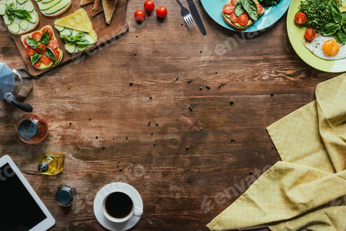 Preview: top view of cup of coffee, tablet, tablecloth and breakfast on wooden tabletop