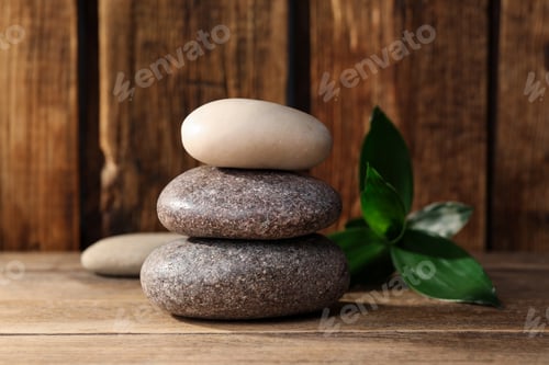 Preview: Stacked spa stones and bamboo leaves on wooden table