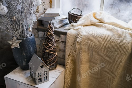 Preview: Vintage Christmas decorations on windowsill. Candles, statuettes and mirror in modern loft interior.