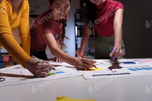 Preview: Three businesswomen are working late in the office, collaborating on a project