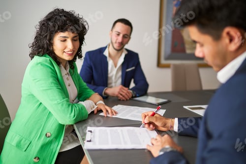 Preview: Businessman signing contract with smiling businesswoman observing