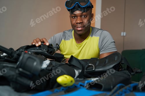 Preview: Assembling of scuba diving suit by mixed-race man
