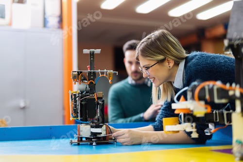 Preview: Young engineer testing her robot in workshop