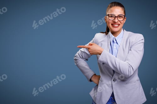 Preview: Young beautiful businesswoman looking at camera smiling and pointing