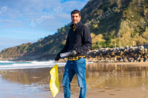 Preview: Volunteer portrait collecting garbage and plastic on the beach. Ecology concept, sea pollution