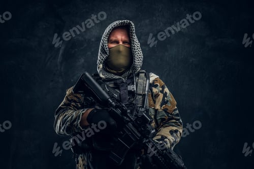 Preview: Special forces soldier wearing body armor holding an assault rifle. Studio photo