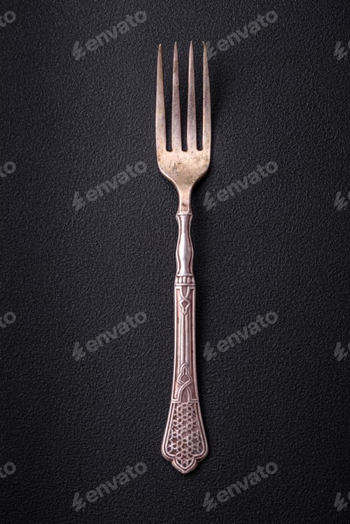 Preview: Metal kitchen fork on a dark textured concrete background