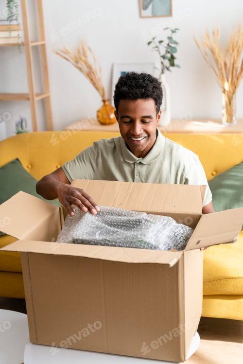 Preview: Cheerful black man unboxing some stuff
