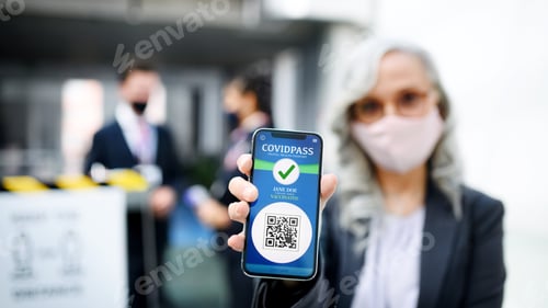 Preview: Senior woman showing smartphone with covidpass, coronavirus, travel and new normal