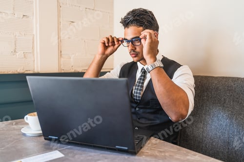 Preview: Focused Man Working on Laptop in Coffee Shop