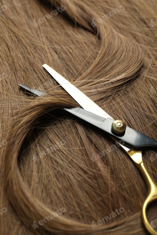 Preview: Scissors with lock of beautiful brown hair, closeup