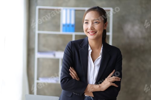 Preview: Portrait of a happy charming business woman looking at the camera in the office.