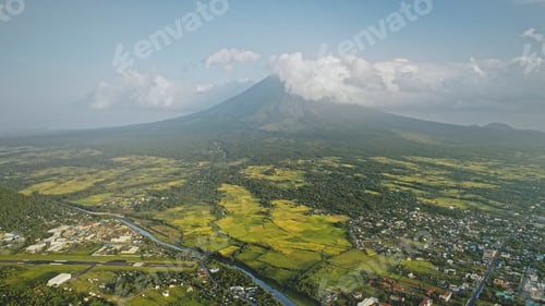 Preview: Volcano erupt at countryside cityscape aerial. Urban cottages with traffic road at green valley