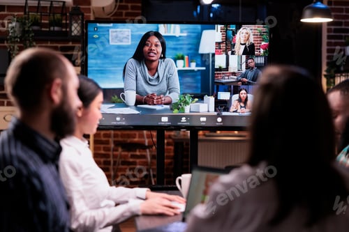 Preview: Multiethnic startup team in online video call with colleagues working remote doing overtime working