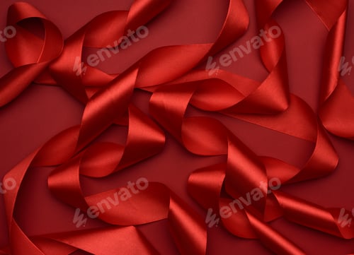 Preview: Curled red silk ribbon on a red background