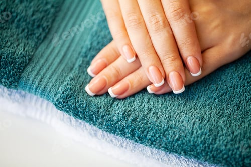 Preview: Beautiful woman's nails with french manicure, in beauty studio
