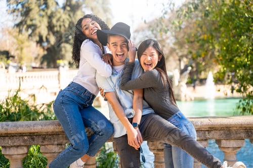 Preview: Three friends having fun visiting a landmark and looking at the camera