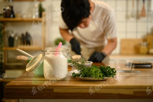 Preview: Kitchen counter with a glass jar of salt, plate of fresh herbs.