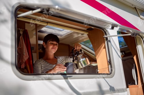 Preview: Woman cooking in camper, motorhome interior