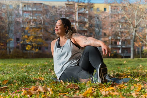 Preview: Brazilian woman stretching on yoga mat in autumn park