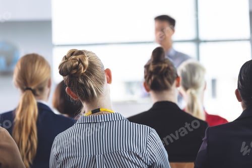 Preview: businesswoman listening to businessman speak at business seminar in office building