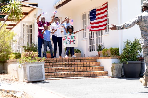 Preview: African American male soldier wearing uniform and his family standing by their house