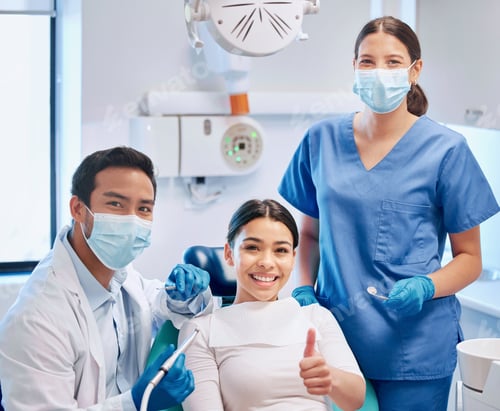 Preview: Shot of a young male dentist giving the thumbs up with his patient and assistant
