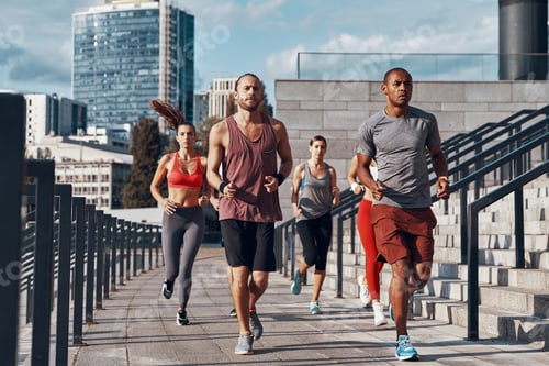 Vista previa: Full length of young people in sports clothing jogging while exercising on the street outdoors