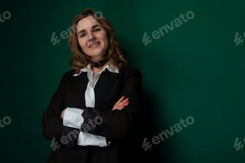 Preview: Woman Standing With Arms Crossed in Front of Green Wall