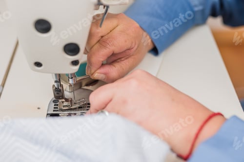 Preview: Atelier process needle detail. Unrecognizable woman hand on a sewing machine doing handmade fabric