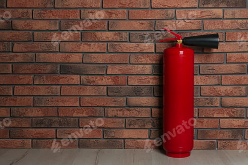 Preview: Fire extinguisher near brick wall indoors, space for text