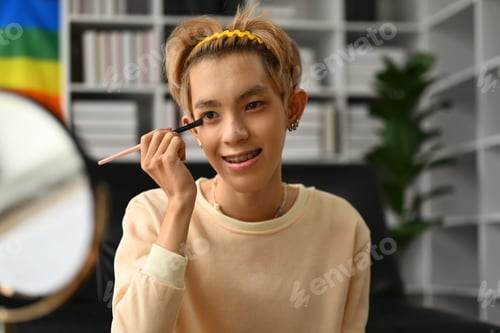 Preview: Pretty gay man beauty blogger applying make while streaming online video tutorial.