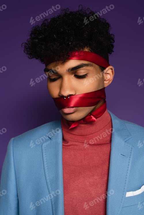 Preview: pierced african american man tied with red ribbon on purple