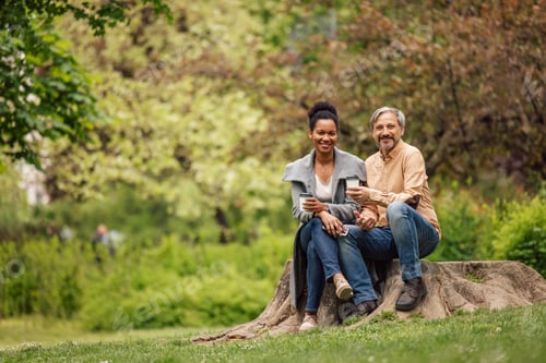 Preview: Adult lovers, happy faces, sitting next to each other, drinking coffee.
