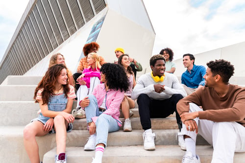 Preview: Happy playful multiethnic group of young friends bonding outdoors