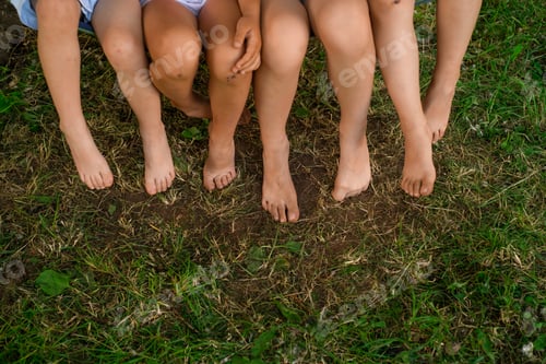 Preview: Children's bare feet close-up on the lawn in the park