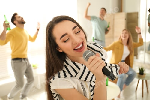 Preview: Young woman singing karaoke with friends at home