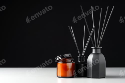 Preview: Black Reed Diffuser and Candle on Grey Surface Against Black Background