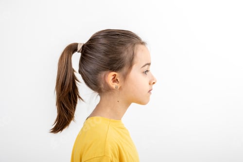 Preview: Side view portrait of girl in yellow t-shirt, isolated on white background.