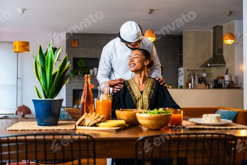 Preview: Happy beautiful young arab couple with emirati clothing having meal together at home
