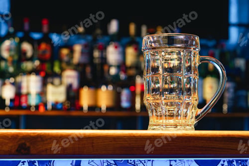 Preview: Empty beer glass on a wooden bar counter